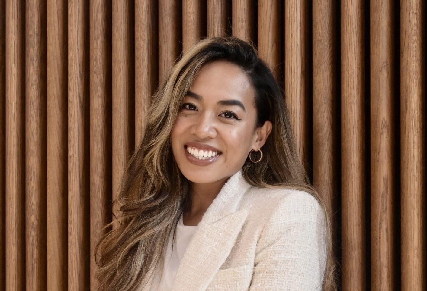 Christiana Agustin sitting in front of panelled background.